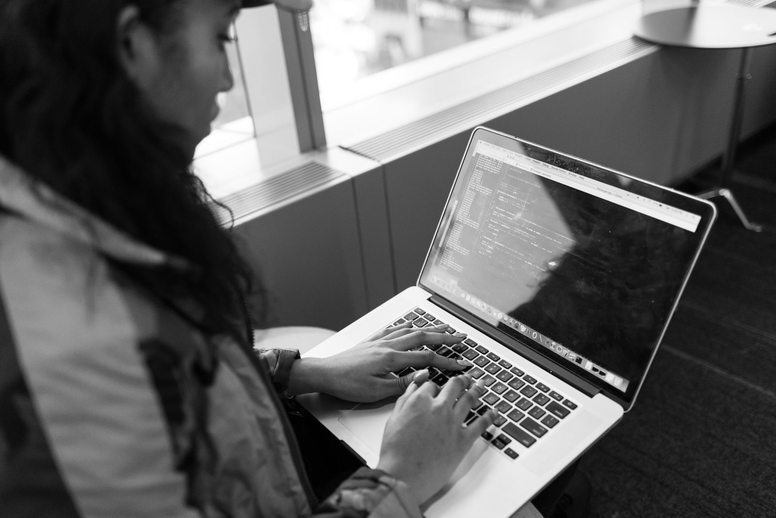 A focused professional typing on a laptop showing a clean modern interface, suggesting an AI search tool returning answers